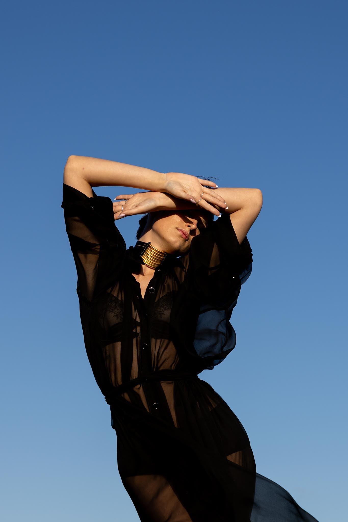 Model wearing Zokkibee Asanti choker necklace in leather and gold plated brass styled for modern fashion