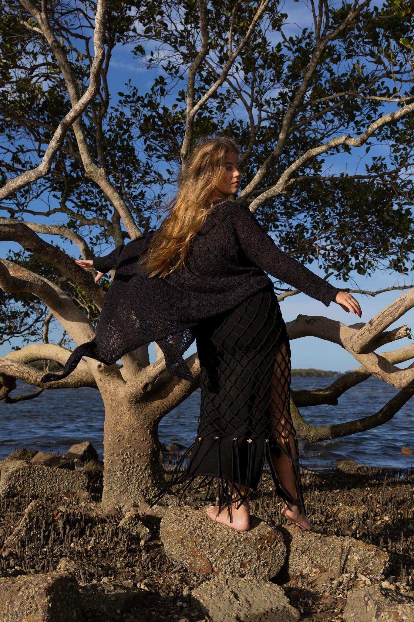 Back view of asymmetric knitted top showing fitted design and unique asymmetric cut