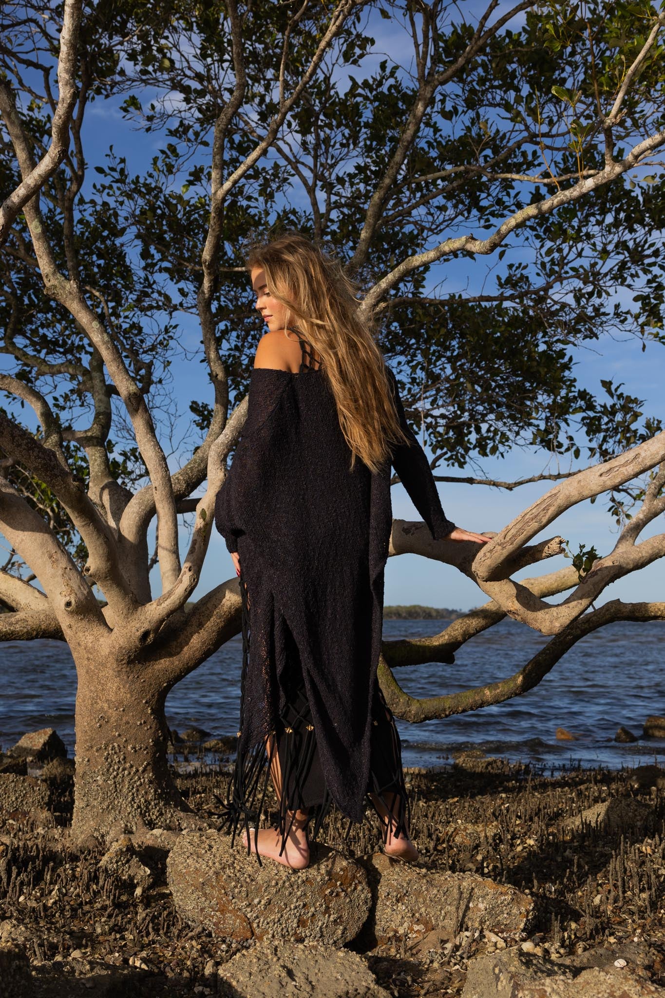 Back view of asymmetric knitted top showing fitted design and unique asymmetric cut