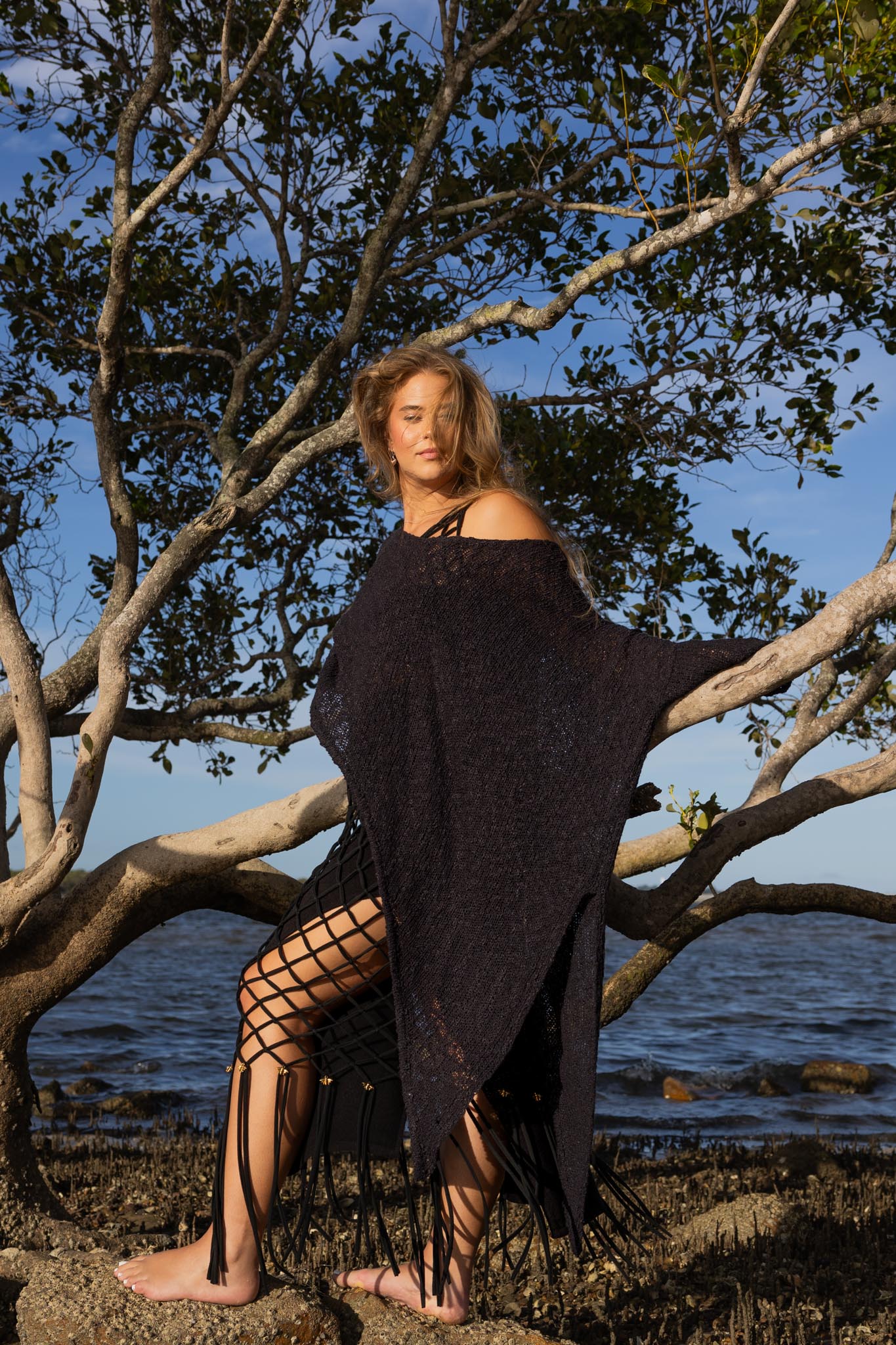 Side angle of Zokkibee asymmetric knitted top highlighting unique asymmetric cut