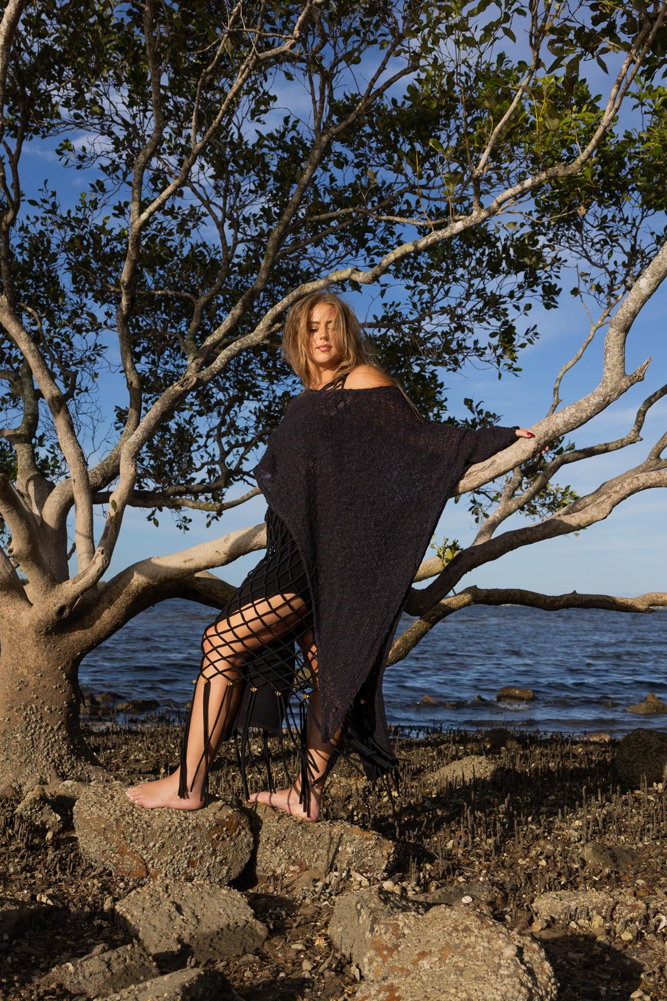 Side angle of Zokkibee asymmetric knitted top highlighting unique asymmetric cut