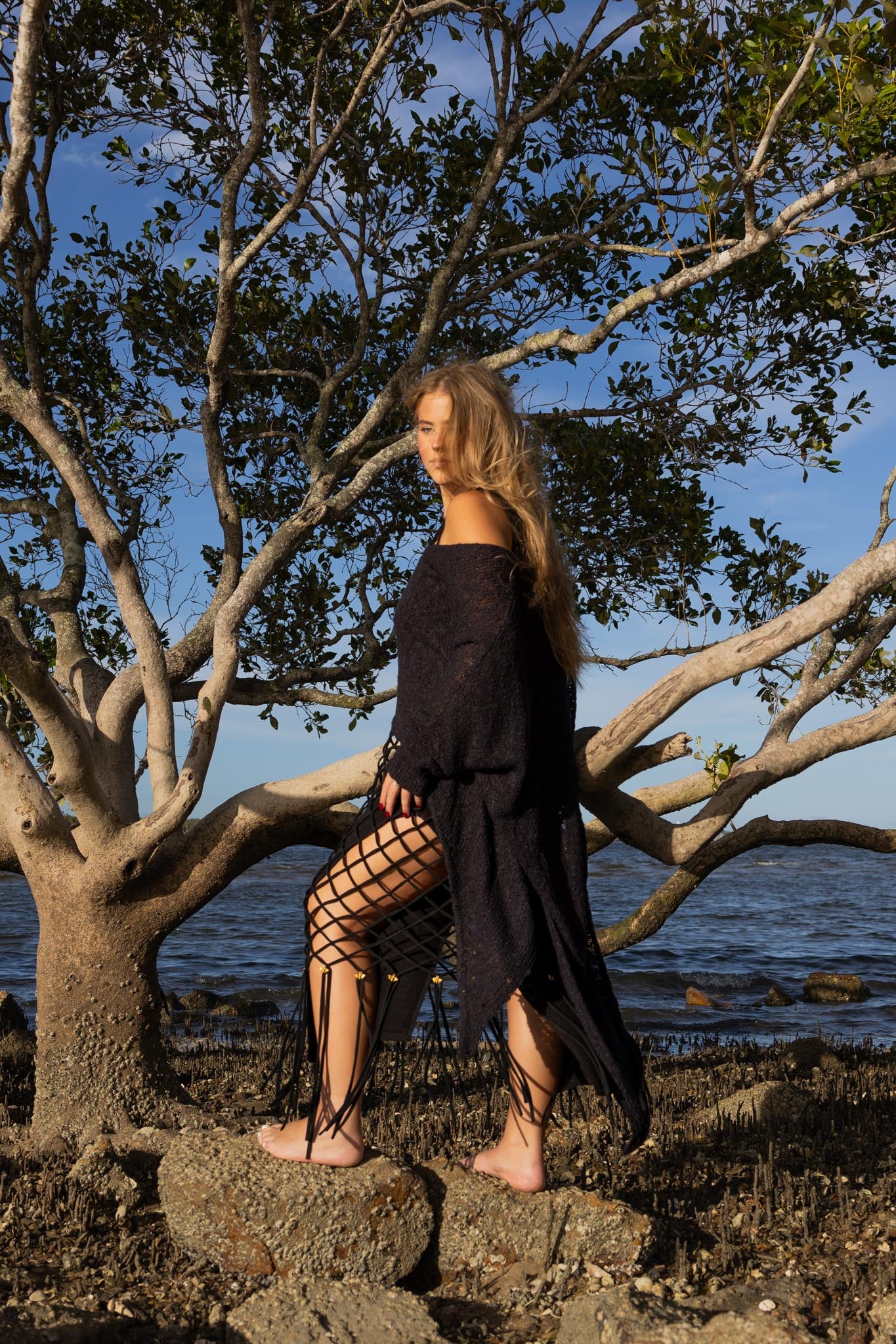 Side angle of Zokkibee asymmetric knitted top highlighting unique asymmetric cut