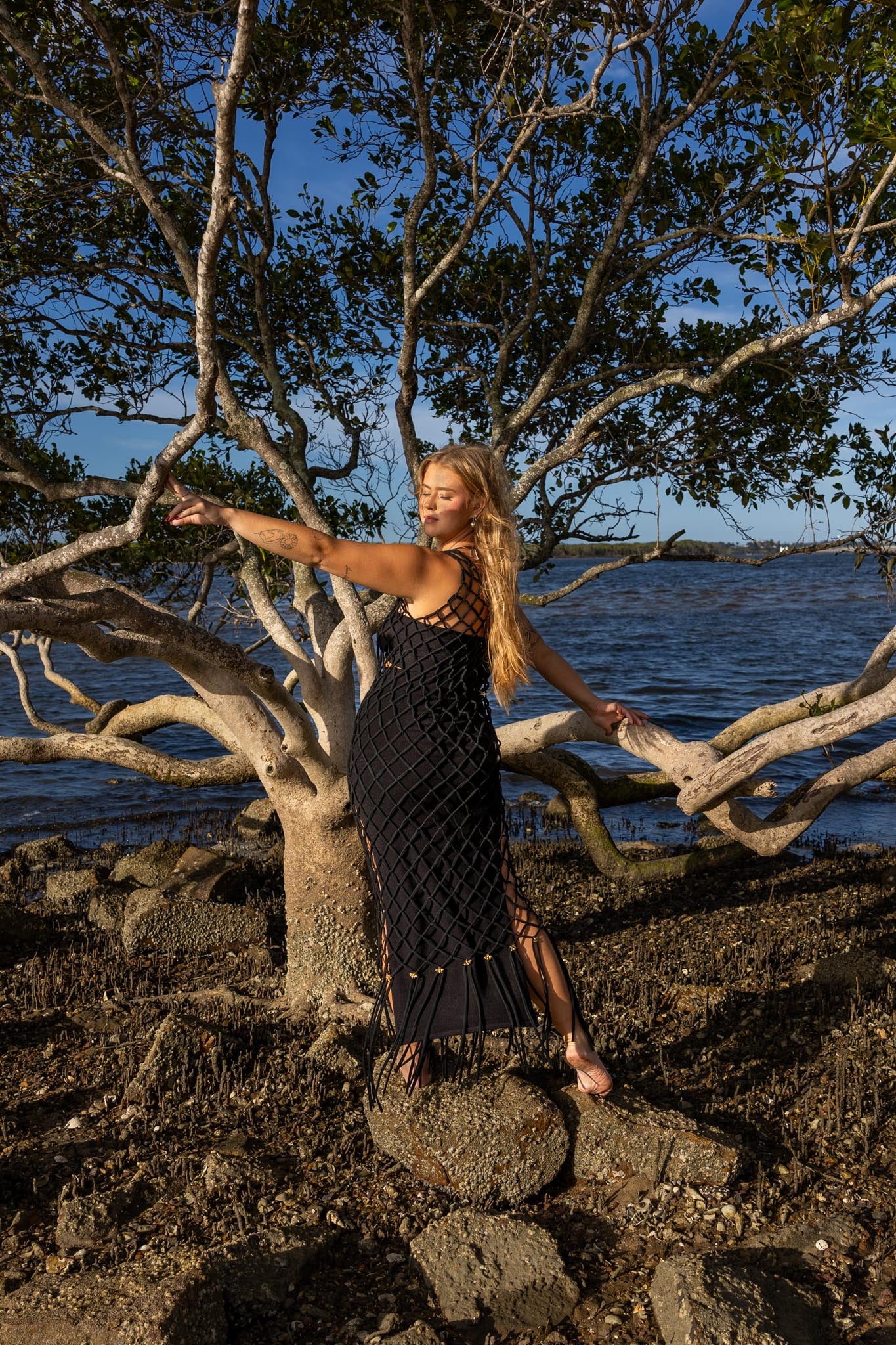 Back view of Inka Obsidian fringe dress showing black fringe details and handcrafted macramé knots.