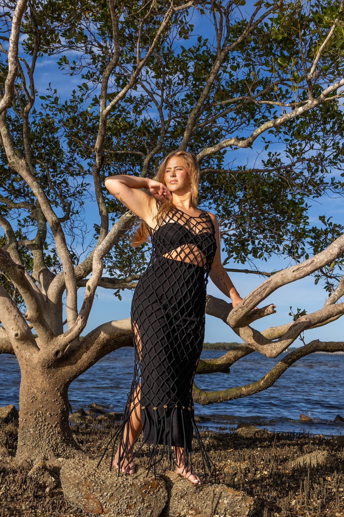 Front view of Zokkibee Inka Obsidian fringe dress in black with artisan macramé knots and dramatic fringe.