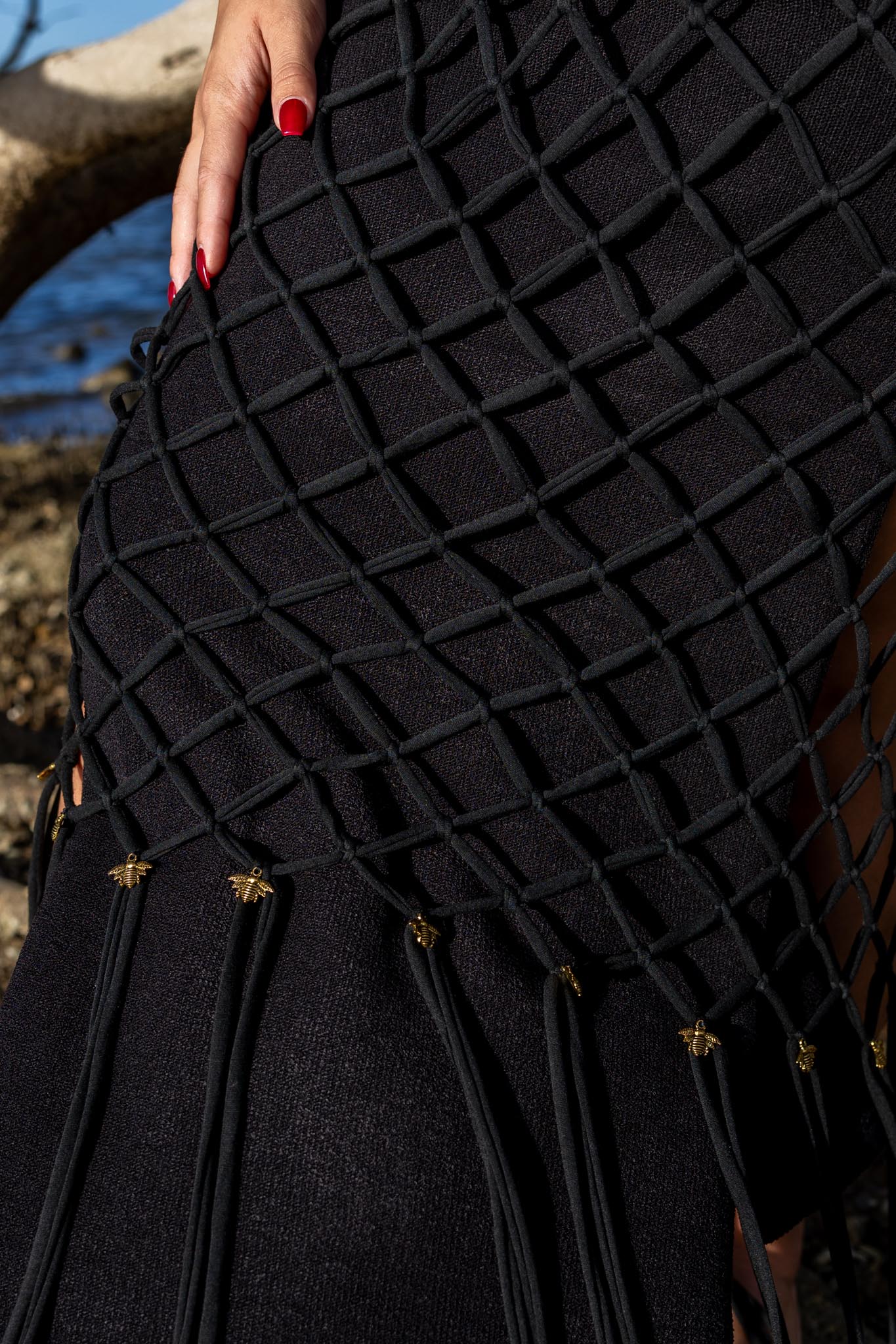 Closeup of artisan macramé knots on Zokkibee Inka Obsidian black fringe dress.