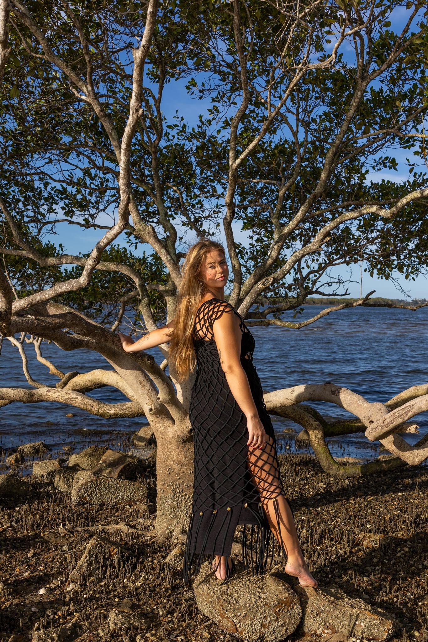 Side view of Inka Obsidian black fringe dress by Zokkibee with macramé knot design.