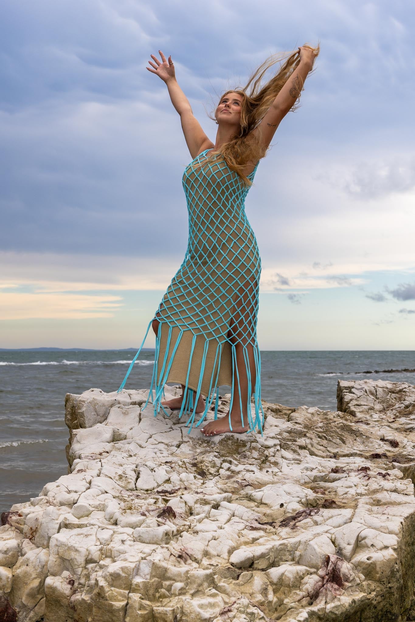 Model wearing Zokkibee Inka Sapphire blue fringe dress with artisan macramé and statement fringe.
