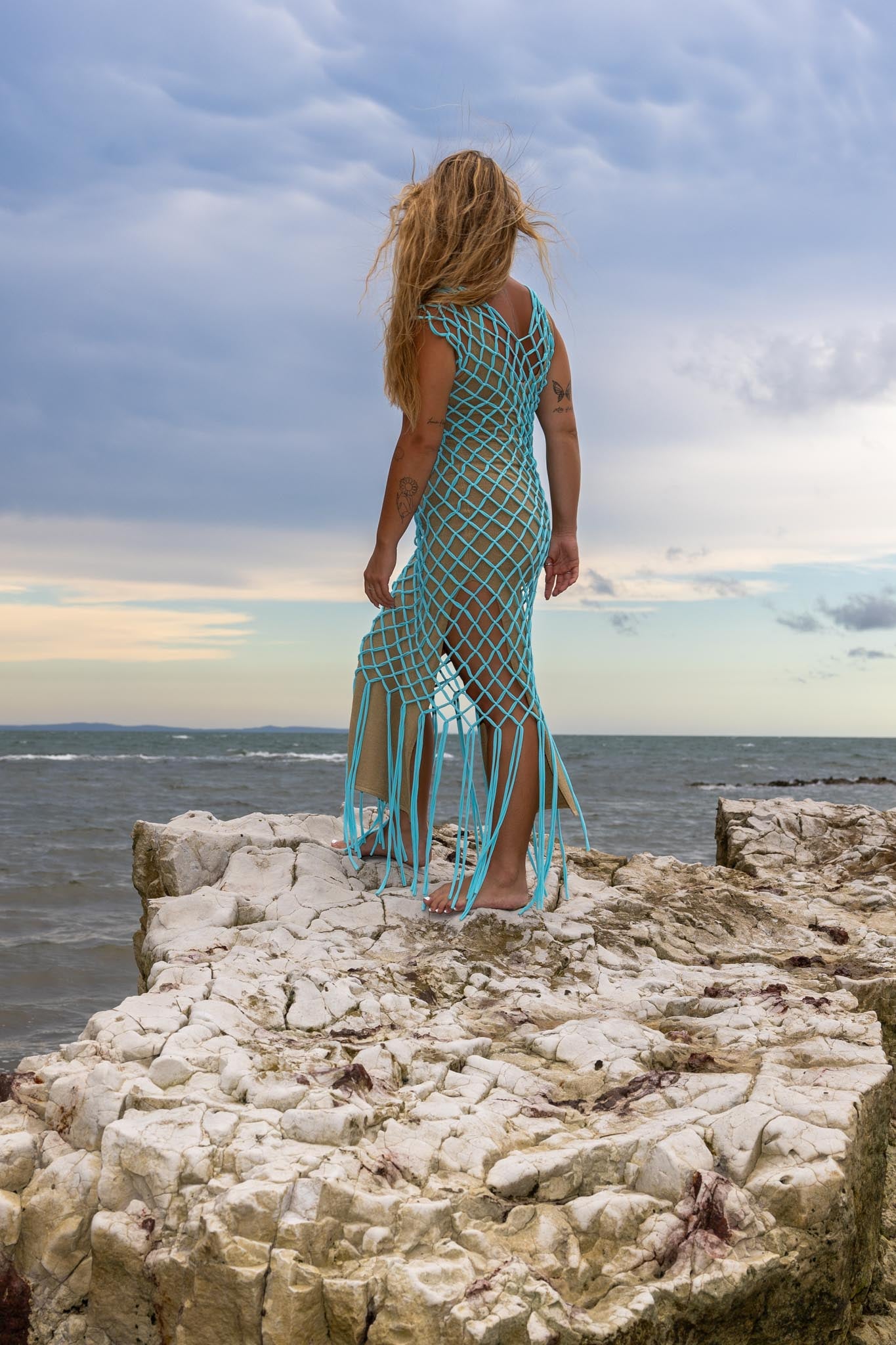 Back view of Inka Sapphire fringe dress showing vivid blue fringe and handcrafted macramé knot details.