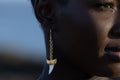 Model wearing Zokkibee shark tooth gold earrings styled for modern, bold fashion