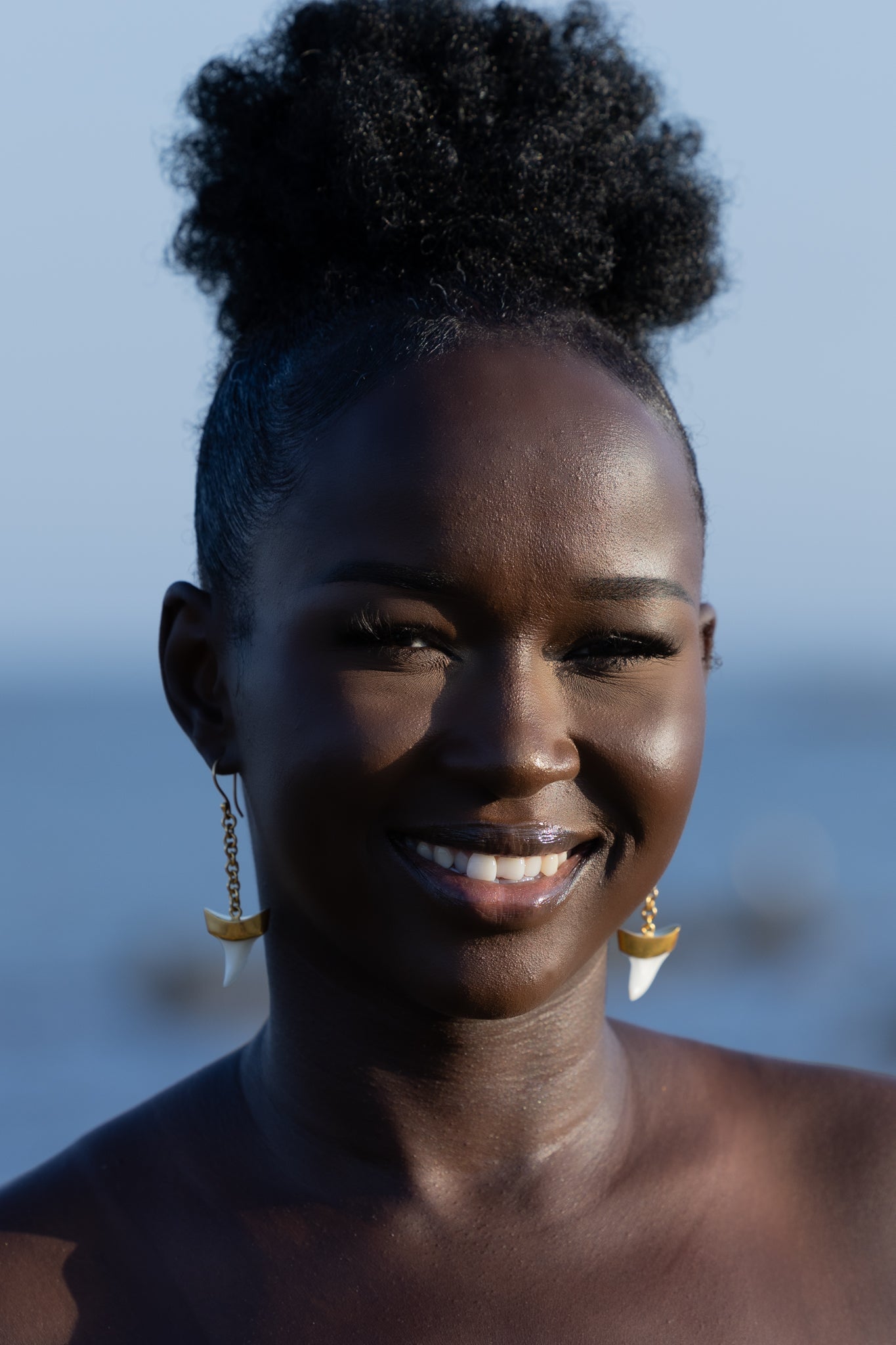 Model wearing Zokkibee shark tooth gold earrings styled for modern, bold fashion