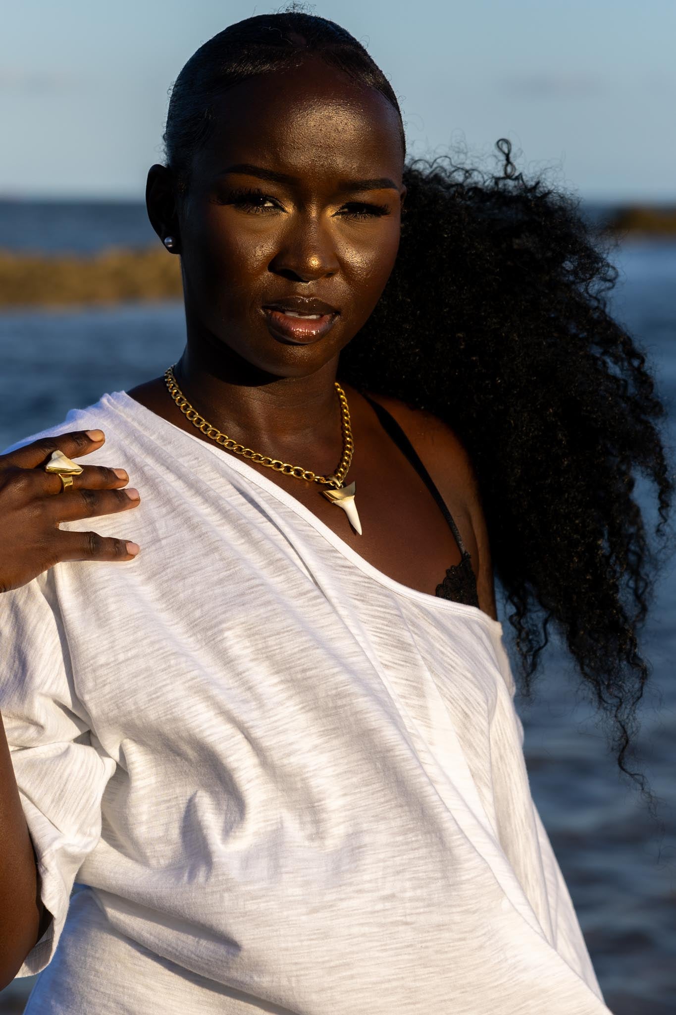 Side angle of Zokkibee shark tooth necklace and ring highlighting shark tooth pendant and gold chain